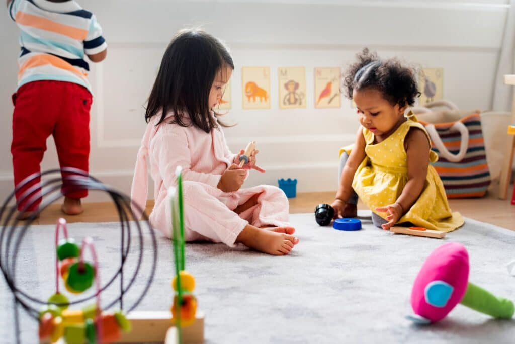 Deux petites filles jouent sur un tapis.